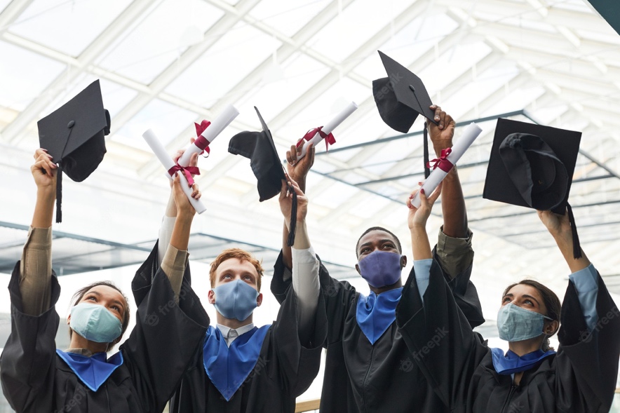 Premium Photo | Diverse group of college graduates throwing hats in air and  wearing masks during graduation ceremony indoors, copy space